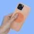 Hand holding a phone with a spiral speks slab sticker on a blue background