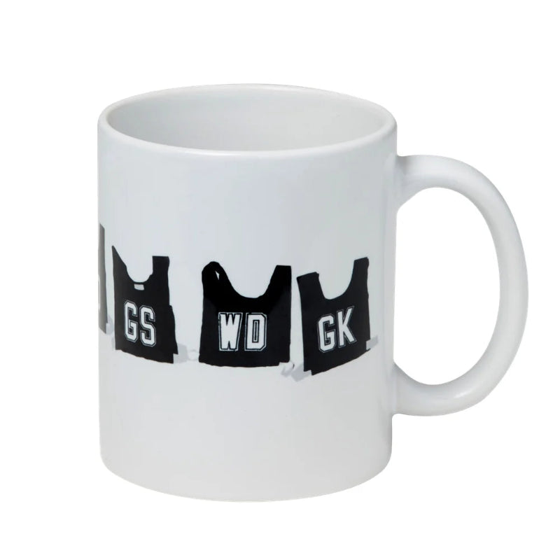 White ceramic mug decorated with black vintage netball bibs marked GS, WD and GK — Adventure Awaits