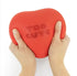 Hands squeezing red The Big Squij heart squishy with Too Cute message Adventure Awaits