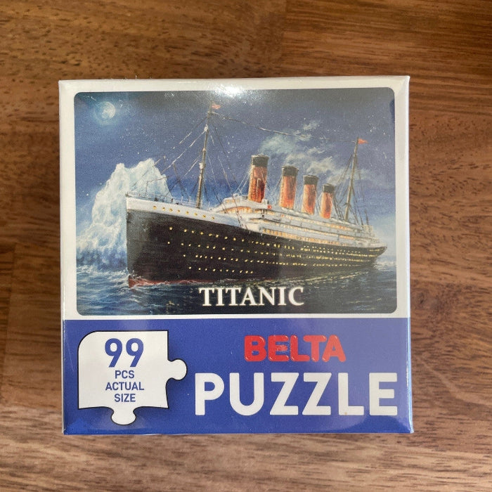 Titanic 99 piece puzzle box on wooden table with ocean liner artwork — Adventure Awaits