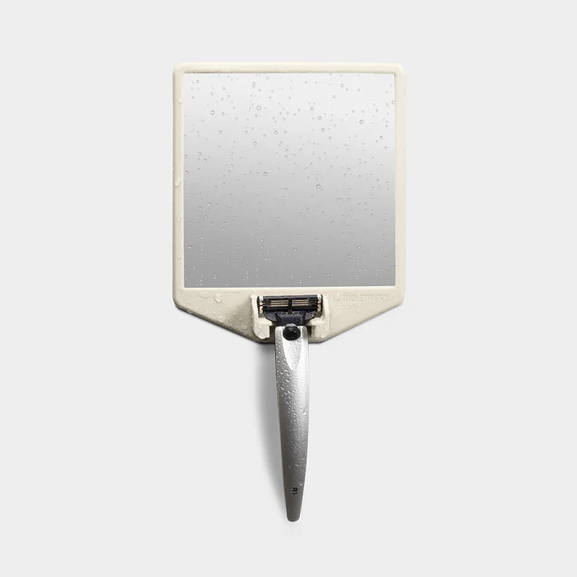 Cream shower mirror with razor holder and water droplets — Adventure Awaits