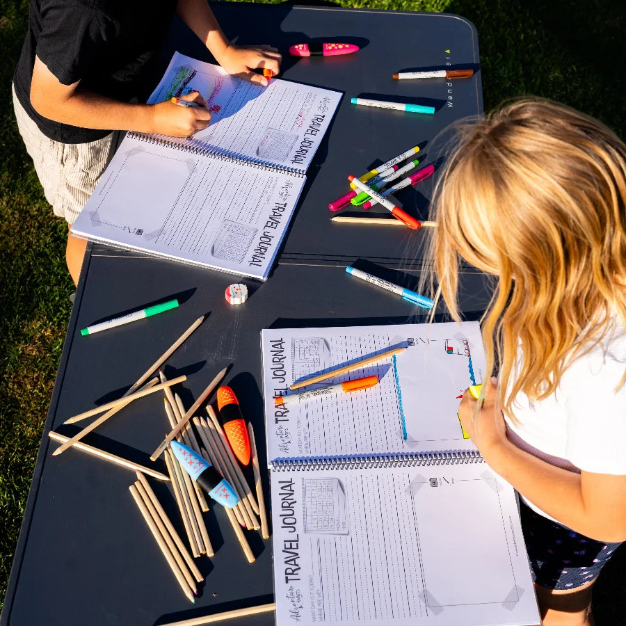 Young children drawing in the spiral bound kids travel journal 