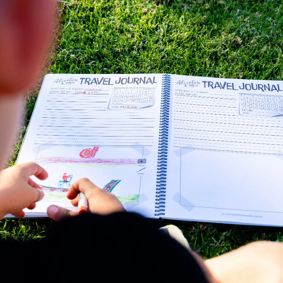 Opened Kids travel journal laying out on grass