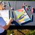 opened and closed kids travel journal on table outside 
