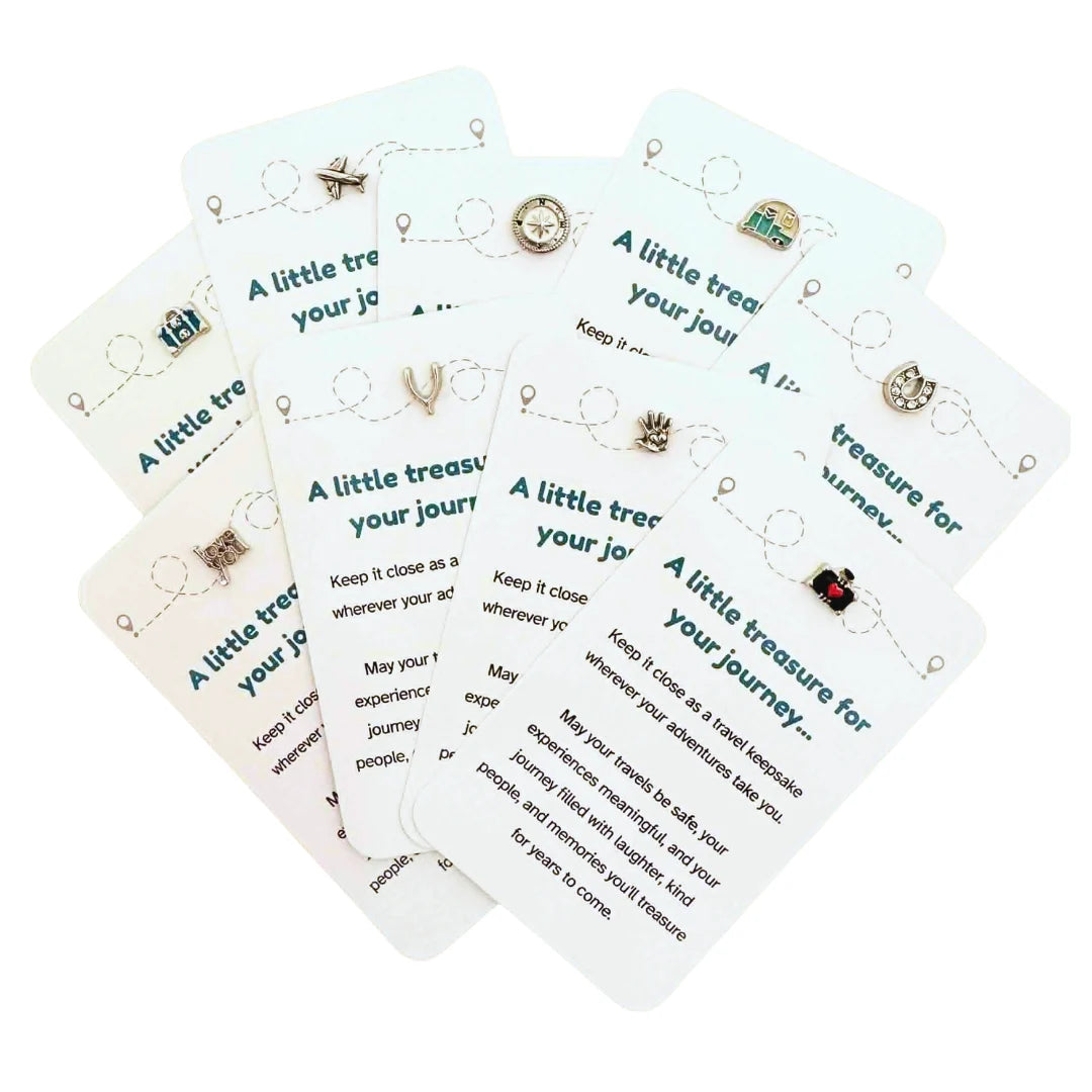 Travel keepsake cards fanned out showing aeroplane, compass, caravan, wishbone and more charm designs — Adventure Awaits
