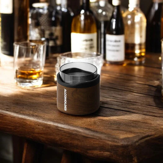 wood grain insulated whisky tumbler on bar table with spirits and glasses in background, modern drinkware for home bar or entertaining Adventure Awaits