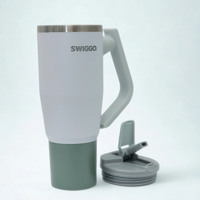 white Swiggo insulated travel tumbler with handle and green base, lid with flip spout shown beside, large reusable drink cup for hot or cold drinks Adventure Awaits