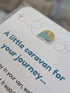Close up of enamel caravan charm on the caravan keepsake card, teal and mustard tones — Adventure Awaits