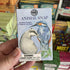Hand holding a 'Animal Snap' card game box with bird illustrations on a store shelf background.