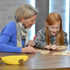 girl and woman playing bananagrams on table