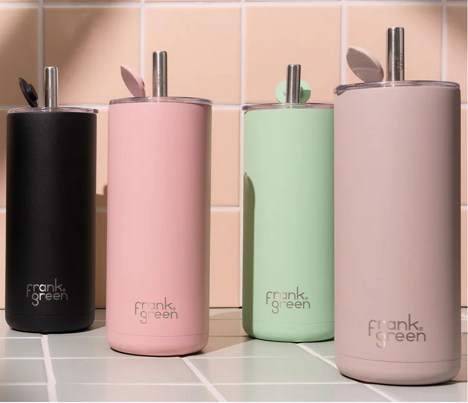 Four reusable cups in black, pink, green, and beige with 'frank. green' branding on a tiled background.