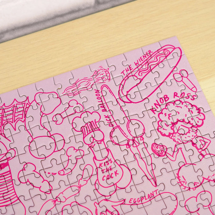 Close-up of the completed pink Penis Puzzle showing cheeky illustrated jigsaw details — Adventure Awaits