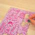 Hand places a piece into the pink Penis Puzzle featuring cheeky illustrated designs — Adventure Awaits