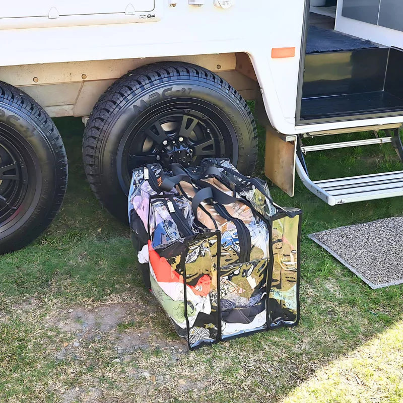 Campaq clear storage bag packed with clothes beside a caravan step at camp — Adventure Awaits