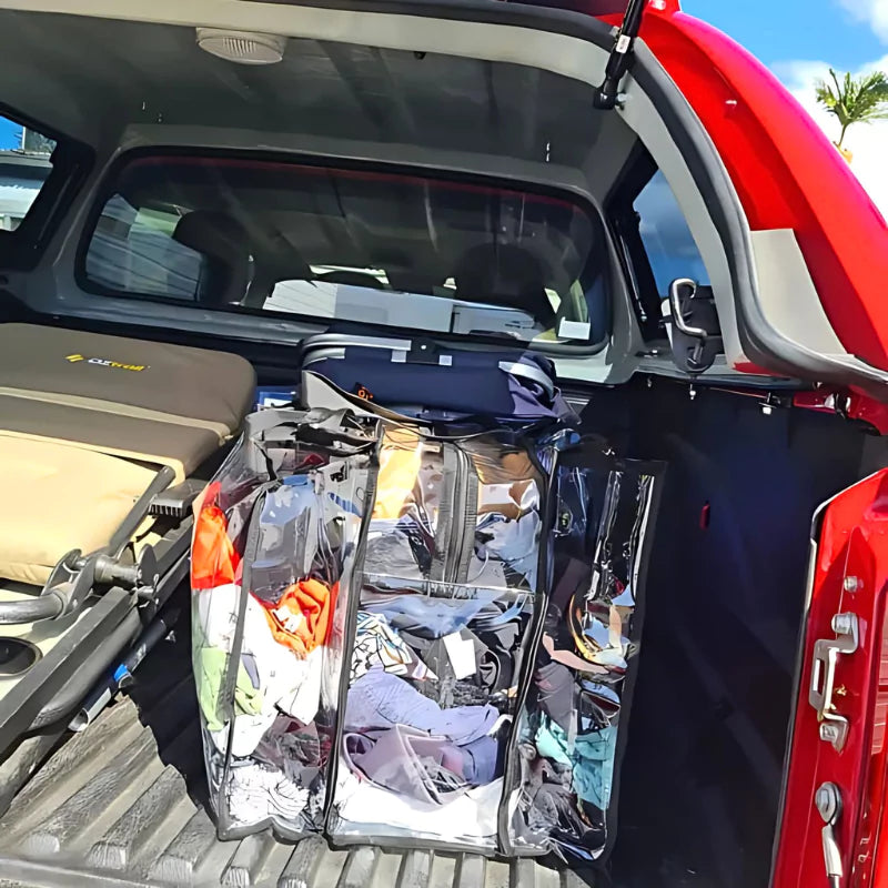 Clear Campaq storage bag packed with clothes in a ute tray for camping trips — Adventure Awaits