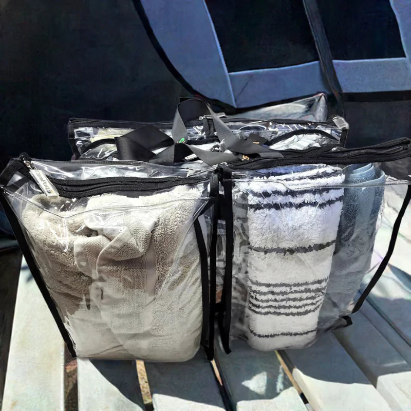 Clear Campaq storage bags packed with towels on caravan seating for organised camping trips — Adventure Awaits