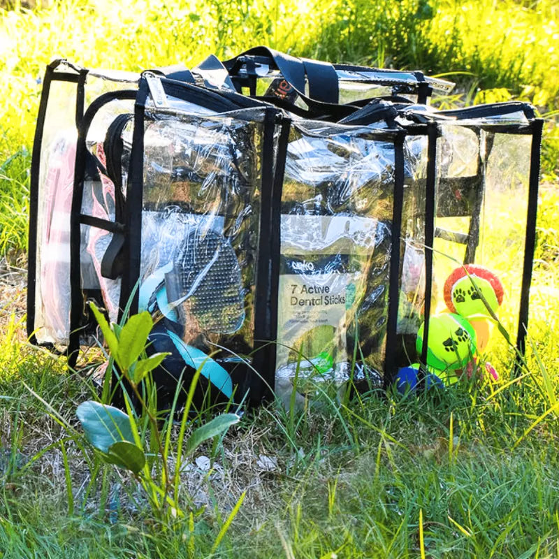 Campaq clear storage bag packed with pet and travel gear on grass at a campsite — Adventure Awaits