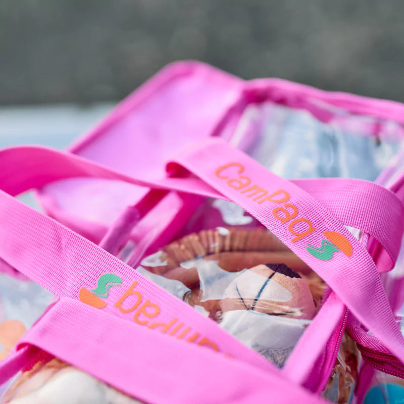 Close up of pink Campaq clear toiletry storage bag with branded straps and packed toiletries — Adventure Awaits