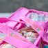 Close up of pink Campaq clear toiletry storage bag with branded straps and packed toiletries — Adventure Awaits