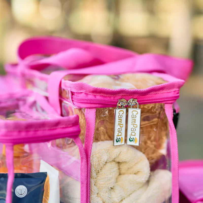 Close up of pink Campaq clear toiletry storage bag with branded zips and towel inside — Adventure Awaits