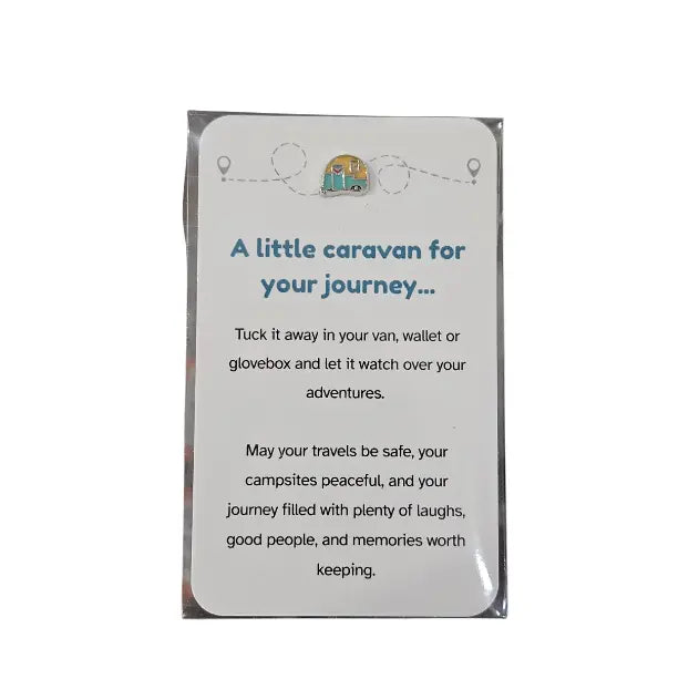 A printed card or note inside a clear plastic sleeve, with a white rounded rectangle front and blue text reading 'A little caravan for your journey.