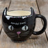 Black cat-shaped mug with 'purr-fect friend' text on a wooden surface