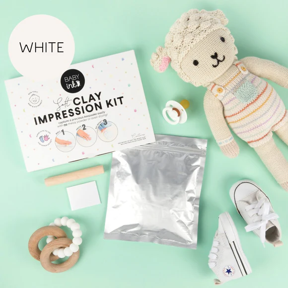 clay impression kit packaging and contents shown alongside baby toys and shoes on a green background