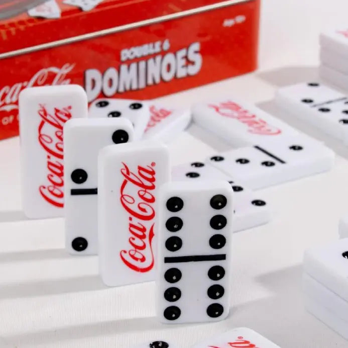 Coca-Cola dominoes game pieces close-up with red logo and black dots — Adventure Awaits