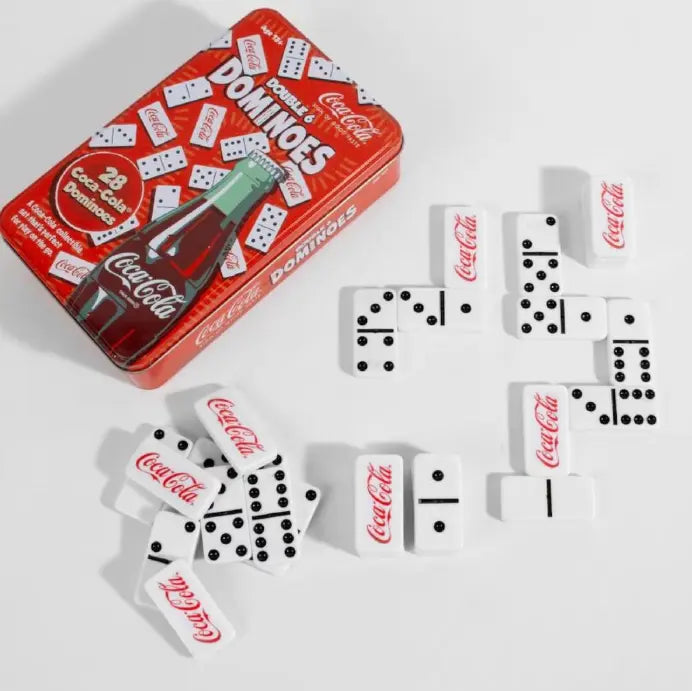 Coca-Cola dominoes game with red tin and white domino pieces laid out — Adventure Awaits