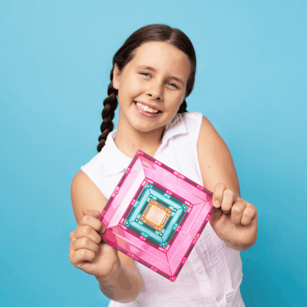 smiling child holding colourful Connetix magnetic tile square design, creative construction toy for imaginative play and learning at home or travel Adventure Awaits