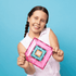 smiling child holding colourful Connetix magnetic tile square design, creative construction toy for imaginative play and learning at home or travel Adventure Awaits