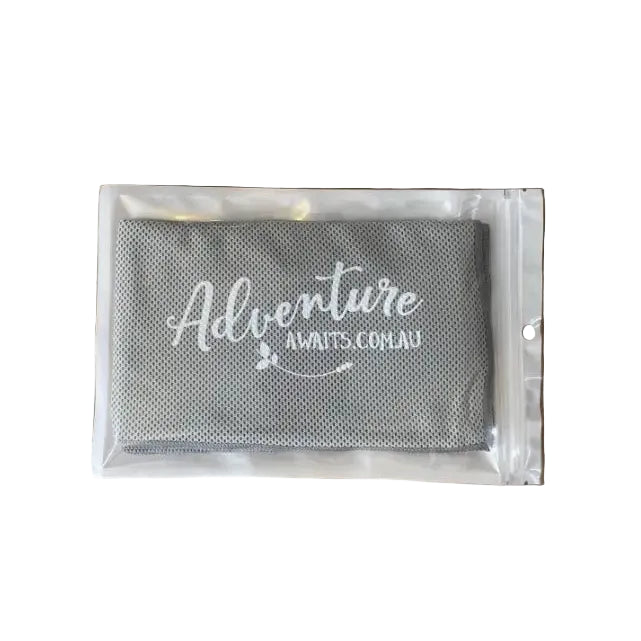 Grey Adventure Awaits cooling towel folded in a clear resealable pouch — Adventure Awaits