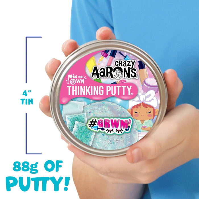child holding Crazy Aaron’s #GRWM Mix Your Own Thinking Putty tin with 88 grams of clear pastel putty