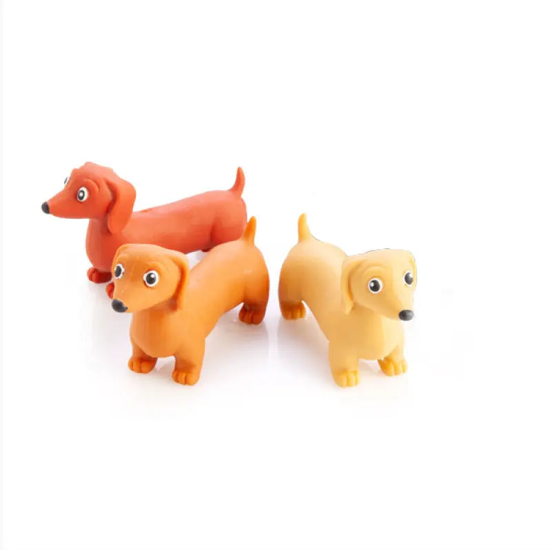 Three sausage dog figurines in orange and yellow colours for playful kids fun — Adventure Awaits