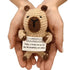 hands holding a handmade crochet bear plush toy with a humorous “Currently Unsupervised” quote sign