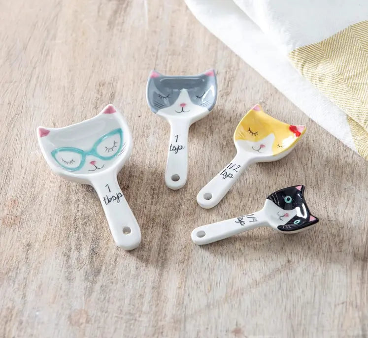 Cat ceramic measuring spoons on wooden bench with tea towel — Adventure Awaits