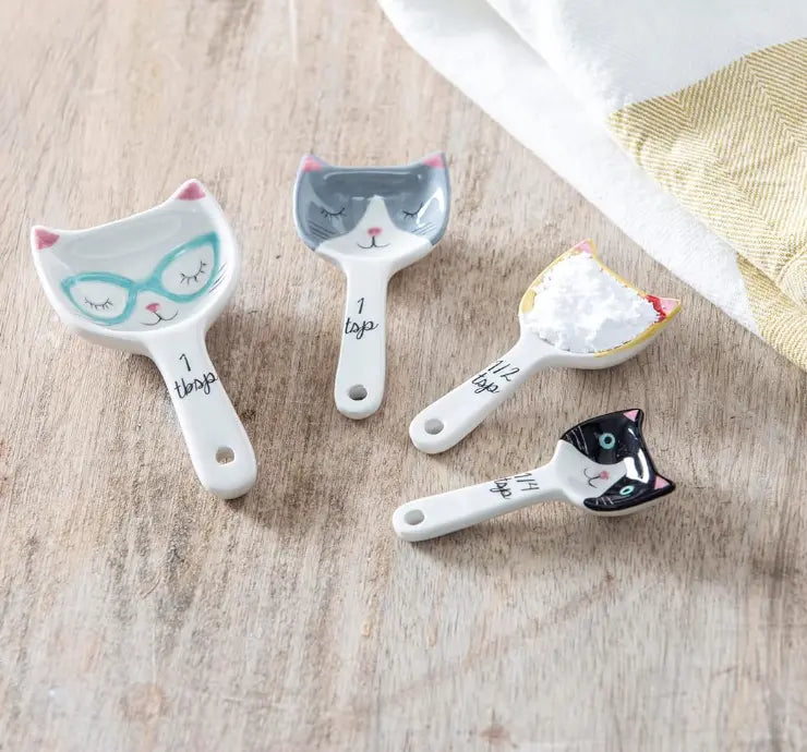 Cat ceramic measuring spoons with flour on wooden bench — Adventure Awaits