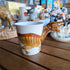 Ceramic mug with a dinosaur design on a wooden surface
