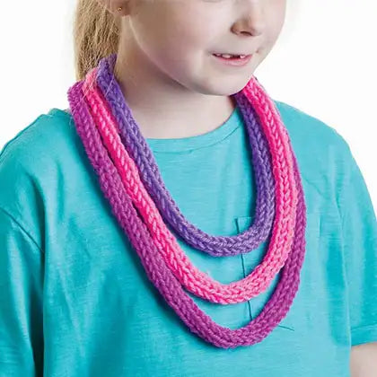 child wearing handmade knitted cord necklace in pink and purple from French knitting kit, creative kids craft result Adventure Awaits