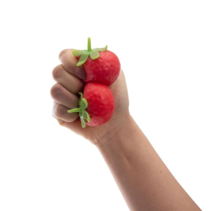 hand squeezing soft strawberry squishy toy, textured red sensory toy for stress relief and kids play Adventure Awaits