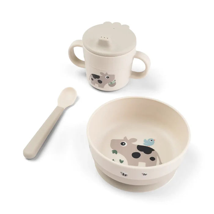 Baby feeding set with suction bowl, spoon and handled cup with lid in neutral tones featuring cow design, ideal for mess free meals at home or travel Adventure Awaits