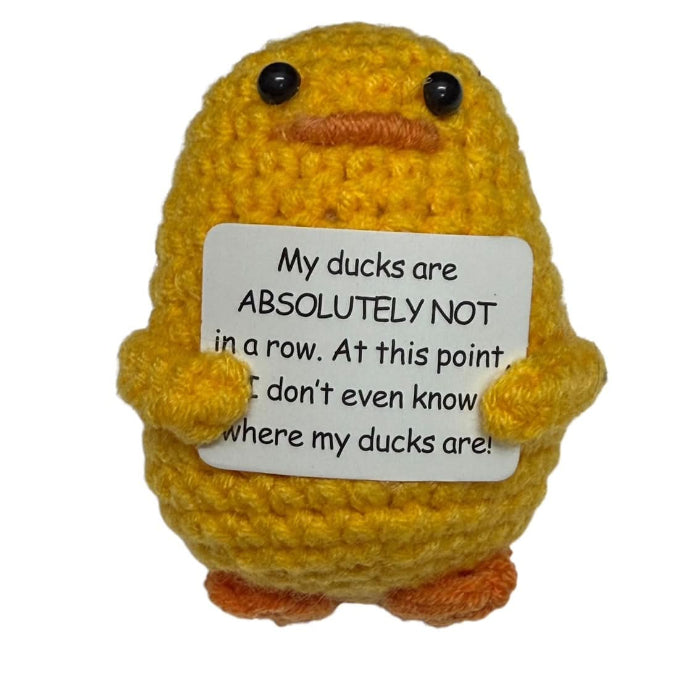 handmade crochet duck plush toy holding a humorous sign about not knowing where the ducks are