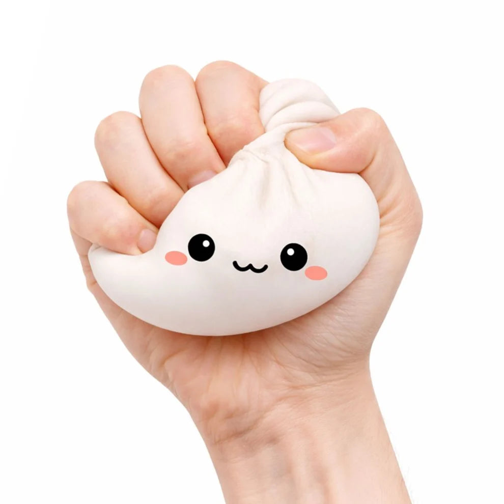 Hand holding a cute white lucky bao bun-shaped stress reliever with a face on a white background