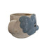 Ceramic elephant shaped object on a white surface with a blurred background