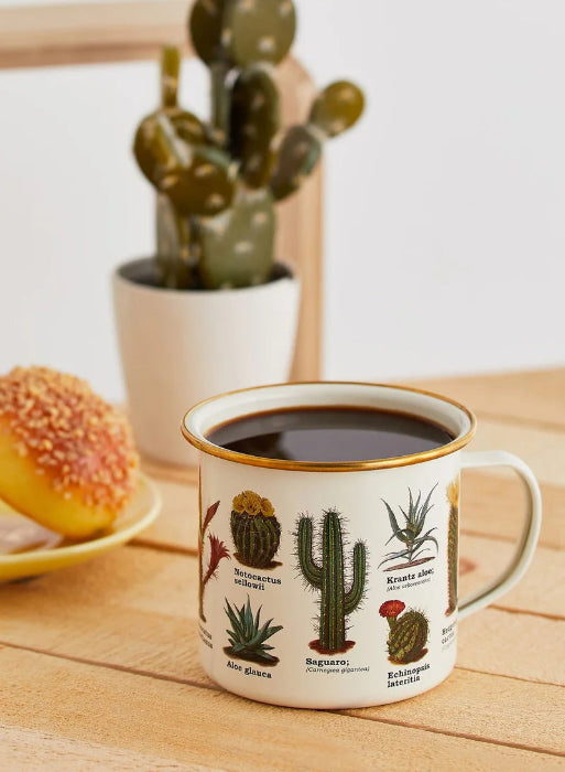 enamel mug with cactus illustrations filled with coffee on wooden table, gold rim camping mug styled with plant and pastry Adventure Awaits