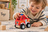 Child playing with Koala Dream red wooden fire truck on a playroom rug — Adventure Awaits