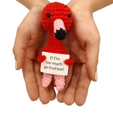hands holding a handmade crochet flamingo plush toy with a confident “If I’m too much, go find less” sign