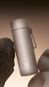 Moondust Frank Green bottle with flip lid and strap styled between natural rocks — Adventure Awaits