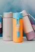 Frank Green reusable bottles with clip-on lip gloss holders in pastel colours and bright orange with blue top and holder — Adventure Awaits