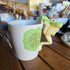Decorative mug with a frog design on a wooden surface